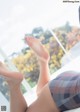 A woman laying on top of a bed with her feet up.