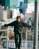 A woman standing on top of a metal railing.