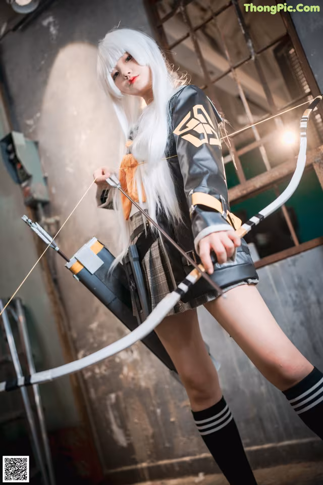 A woman in a black and white outfit holding a bow and arrow.